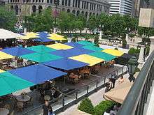 An open-air cafe with umbrellas over the tables