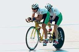 Two women riding a tandem bicycle