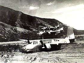 Three twin-engined military aircraft flying low over a valley