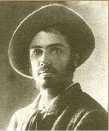 Black and white portrait photograph of Adolphe Appia in his thirties. He is dark haired and bearded and is wearing a hat with a big round brim.