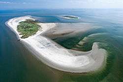 Small island in blue sea, the island consist of a green centre and white beaches