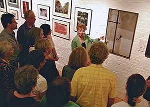 Aesthetic Realism consultant and artist Marcia Rackow speaks on a painting in an exhibit at the Terrain