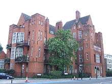 A large red brick building with steep slate covered roofs