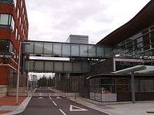 Two covered bridges linking red brick building (left) with glass building (right)