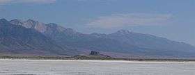 Flat expanse with a mountain range in the distance.