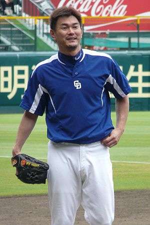 Hitoki Iwase wearing a blue and white baseball uniform standing with his glove