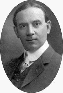 A photographic portrait of a man with thinning dark hair and a three piece suit