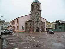 A pink cathedral with a bell tower at the centre