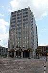 Ground-level view of a 12-story building with a beige facade.