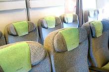 Airline premium economy cabin. Rows of seats arranged between aisles.