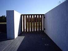 A large wooden gate in a marble wall