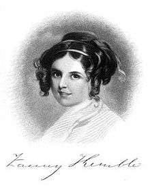 Formal facial portrait photo of attractive young woman with ringlets, smiling softly and looking into the camera.