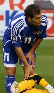 A dark-haired white man wearing blue-and-white sports clothing