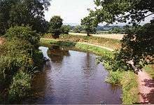 Water with trees on the left and a tow path to the right