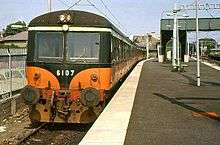 Diesel train standing in a station with a platform to its right