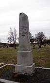 White gravestone in cemetery.