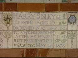 A tablet formed of five tiles of varying sizes, bordered by yellow and blue flowers in an art nouveau style