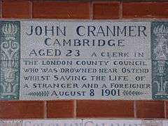 A tablet formed of six standard sized tiles, bordered by green flowers in the style of the Arts and Crafts movement