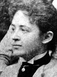 A Caucasian female in profile wearing a high collared shirt with upswept hair.