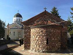 An Orthodox monastery courtyard with a small medieval church to the right and a more modern one to the left