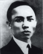 A young man, in a suit with a pale shirt and dark tie