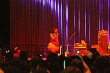 A woman in a red dress on a stage.