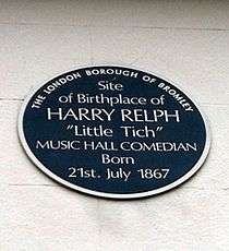 exterior of white bricked wall with blue plaque on front