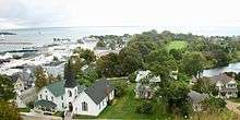 A downhill view of houses. A harbor is visible at left.