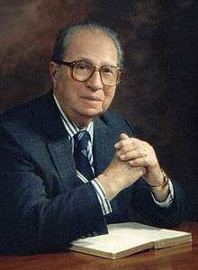 Adler seated at a table in front of an open book