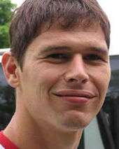 Head of young white man smiling.