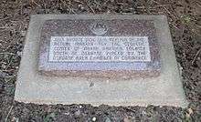 Stone marker with embedded bronze disc; marker reads "This bronze disc is a replica of the actual marker for the geodetic center of North America, located south of Osborne.  Placed by the Osborne Area Chamber of Commerce."