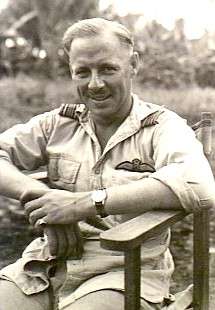 Half-length portrait of seated man in tropical military uniform with pilot's wings on left breast pocket