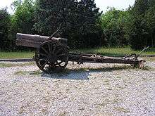 an artillery piece with no gun shield standing on gravel