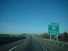 Straight stretch of highway, with an overpass in the distance