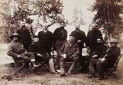 A group of men seated in a forest