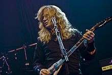 red haired guitarist in a black shirt in front of a microphone