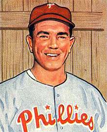 A baseball card image of a smiling man wearing a gray baseball jersey with "Phillies" in red across the chest and a red baseball cap with a white "P" on the front