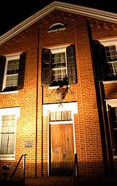 A two-story brick façade photographed at nighttime