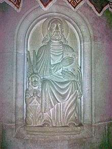 A relief depicting Jesus holding a book and a small angel praying besides him