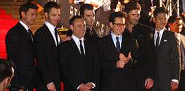 A photograph of some of the cast and crew of Star Trek attending the world premiere in Sydney, Australia. From left: Karl Urban, Chris Pine, Bryan Burk, Zachary Quinto, J. J. Abrams, Eric Bana, and John Cho