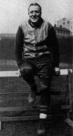 Jock Sutherland sitting on a track and field hurdle.