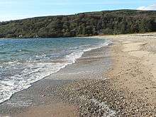 Photograph of surf washing onto a sandy beach