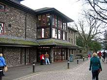 Modern stone-faced theatre with a lake in the background