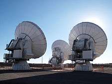 Three large parabolic-dish telescopes, seen from behind