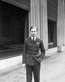 Informal three-quarter portrait of blond man in dark-coloured uniform, with a cigarette in one hand