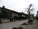 Small street lined by wooden two-storeyed houses.