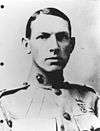 Young man with slicked-down short hair in a circa 1915 U.S. Marine uniform with a very high collar.