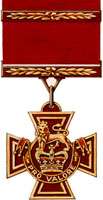 A bronze cross pattée bearing the crown of Saint Edward surmounted by a lion with the inscription Pro Valore. A Bar crosses the crimson ribbon attached to the medal.