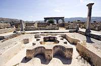 View across a ruined bath complex showing the basins and water features